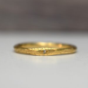 18kt geelgouden trouwring met klein diamantje en organische vorm